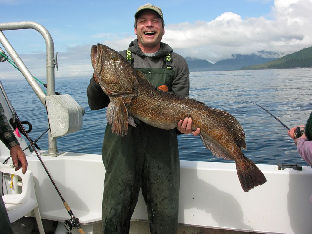 A man holding his prize catch after a successful day of Alaskan fishing.